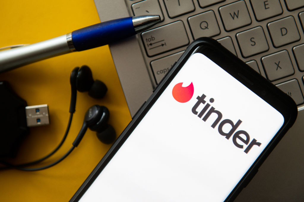 In this photo illustration a Tinder logo seen displayed on a...