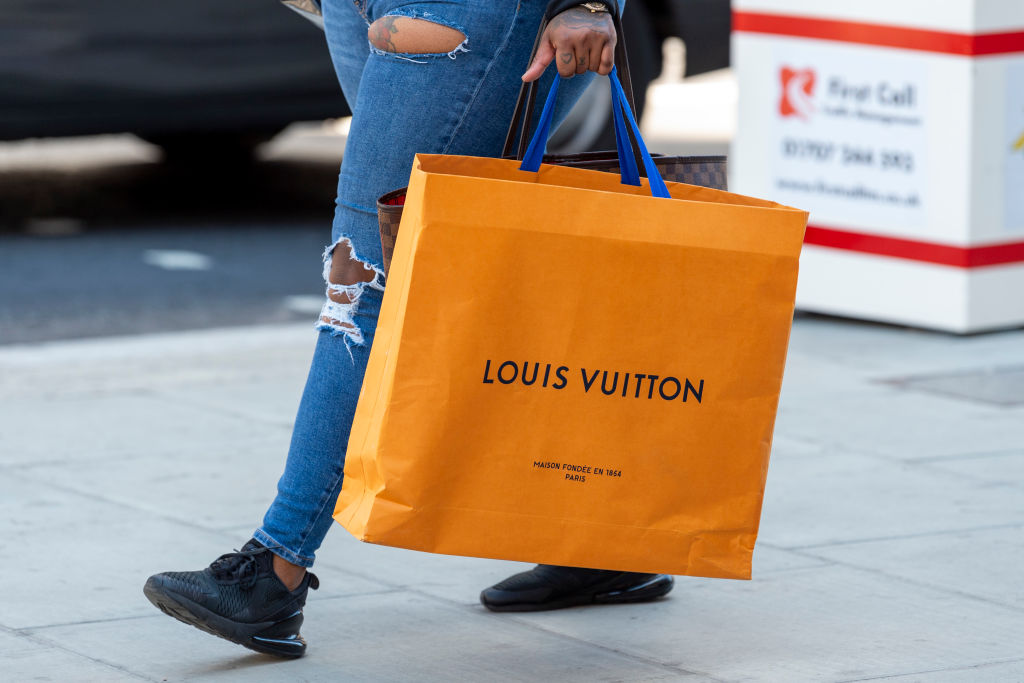 A shopper carries a Louis Vuitton shopping bag on Londons...