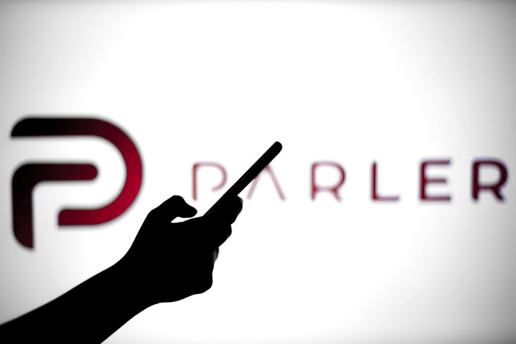 In this photo illustration a Parler logo is seen behind a...