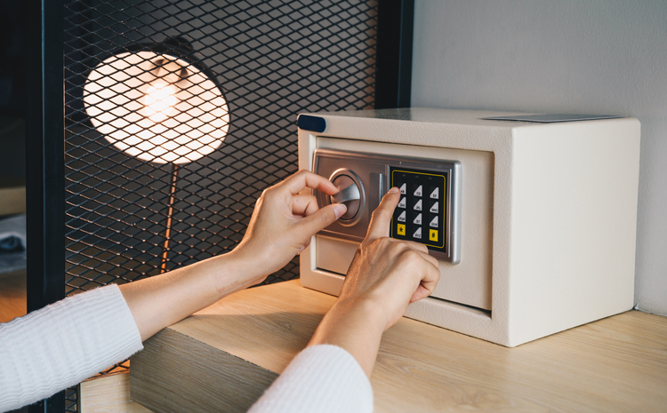 Someone hand trying to press passwords on safety lock pad for open a safety box.