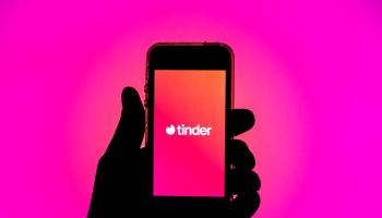 In this photo illustration, the Tinder app seen displayed on...