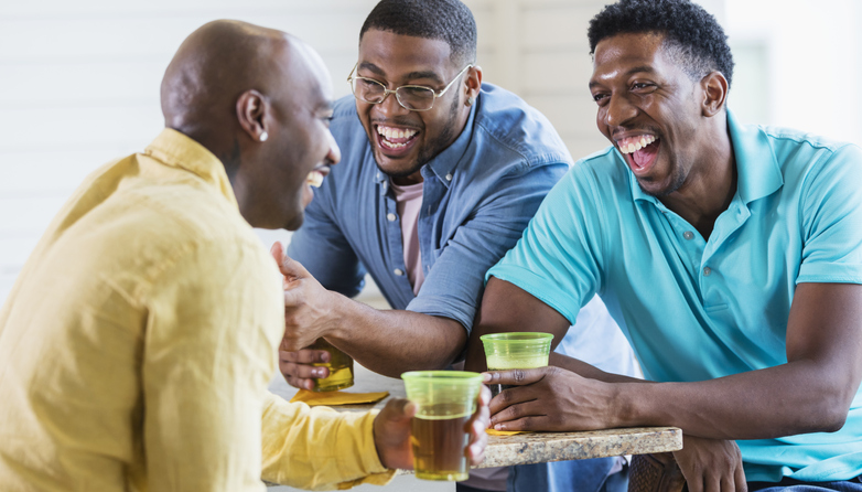Three African-American men talking, drinking, laughing