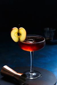 cocktail in coupe glass with apple garnish