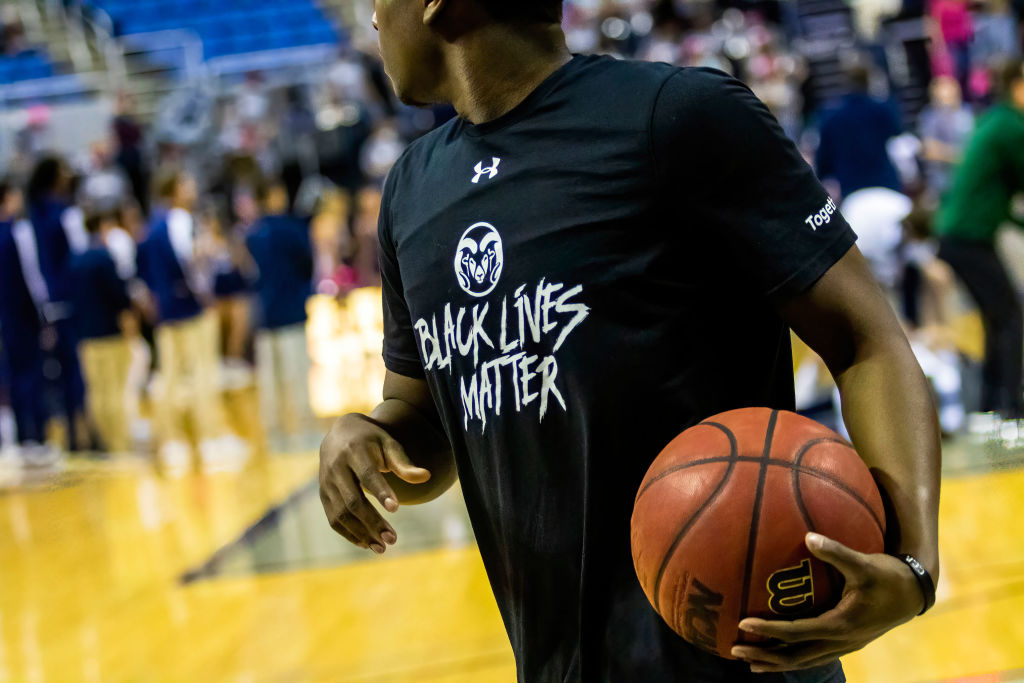 A Colorado Rams basketball player warms up wearing a Black...