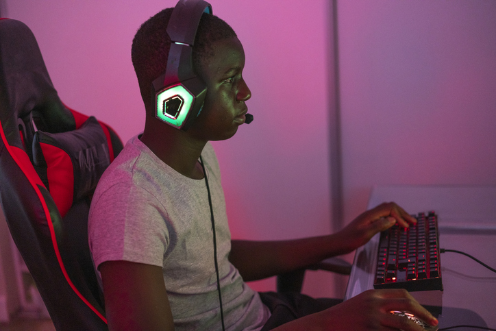 Portrait of young black male gamer playing at station