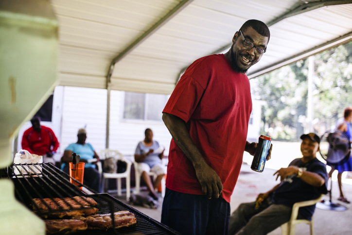 Black man with family and friends cooking Ribs