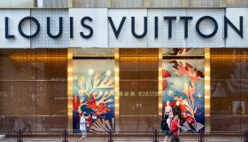Shoppers walk past the French luxury fashion brand Louis...