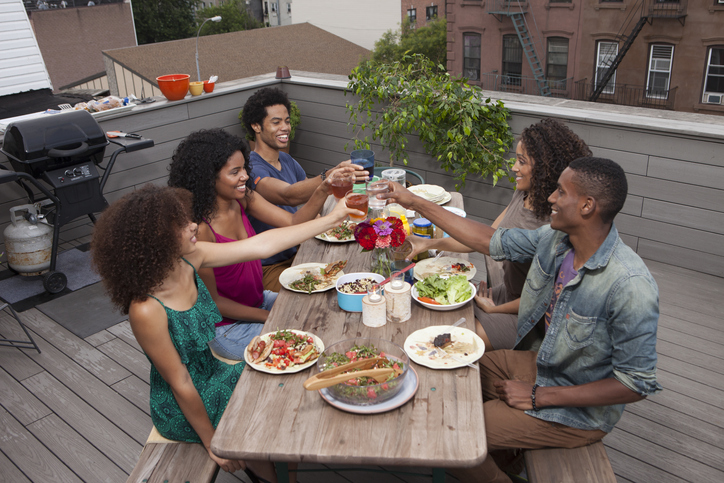 Friends seated at a picnic table toasting