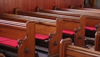Rows of traditional wooden church pews