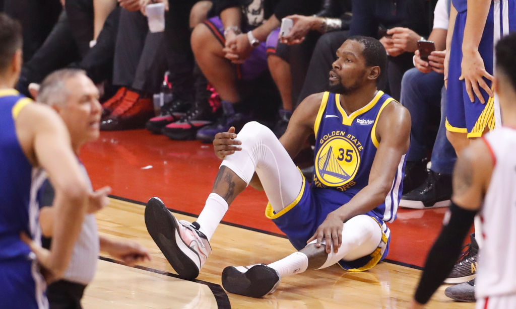 Golden State Warriors Kevin Durant sits on the floor after sustaining an injury to his right leg in the second quarter during game 5 of the NBA Finals between the Golden State Warriors and the Toronto Raptors at Scotiabank Arena on Monday, June 10, 2019