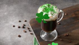 Irish coffee in green cup and special cupcakes for St Patrick s Day.