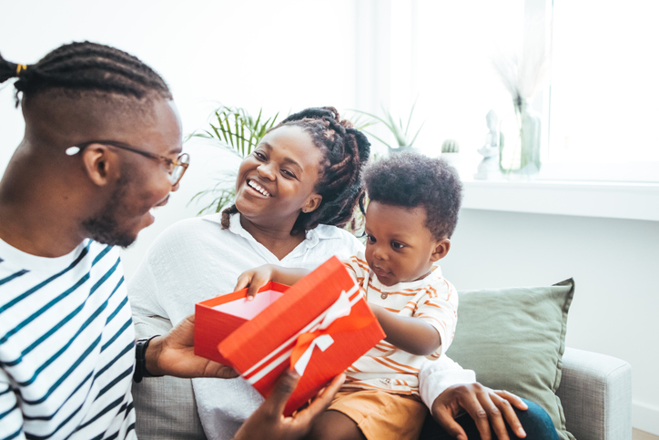 Black Family Enjoying Gift Opening in Home Living Room