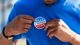 Cropped view of man putting I Voted sticker on shirt