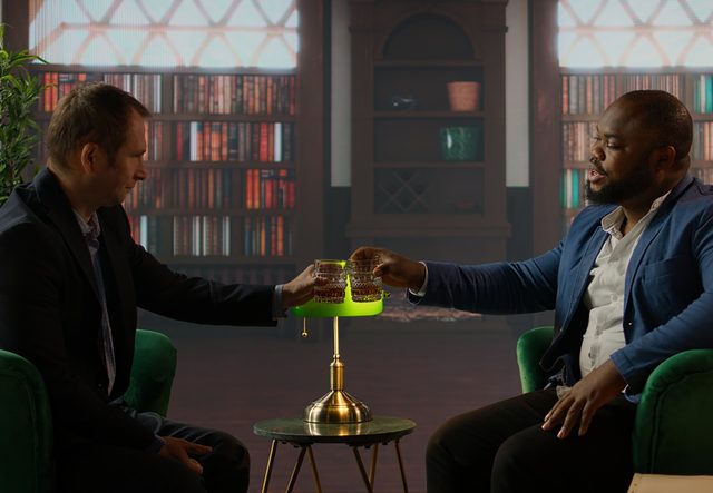 Diverse gentlemen clinking glasses of whiskey and toasting after negotiations