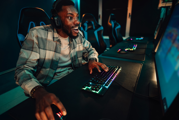 Excited young man playing video game in gaming cafe