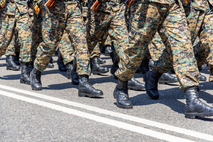 Group of soldiers marching in camouflage uniforms outdoors