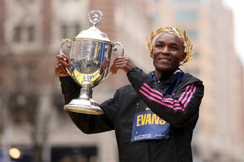 Kenya's Evans Chebet raising trophy at the 2023 Boston Marathon
