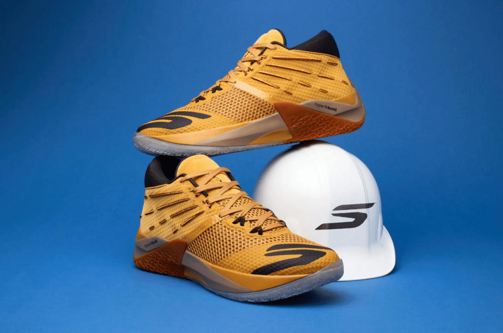 A pair of yellow and black athletic shoes with a white helmet on a blue background.