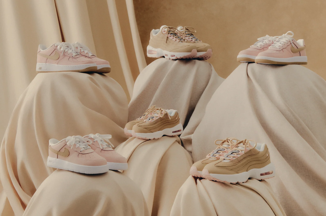 Several pairs of beige and pink sneakers on a beige cloth background.