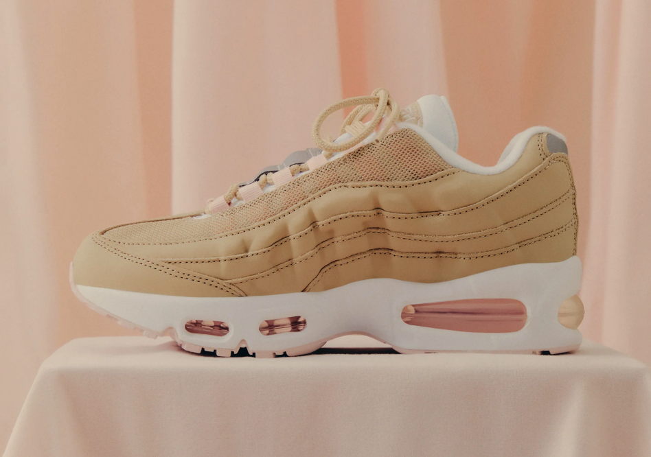 Beige sneaker with white sole and laces on a pink background.