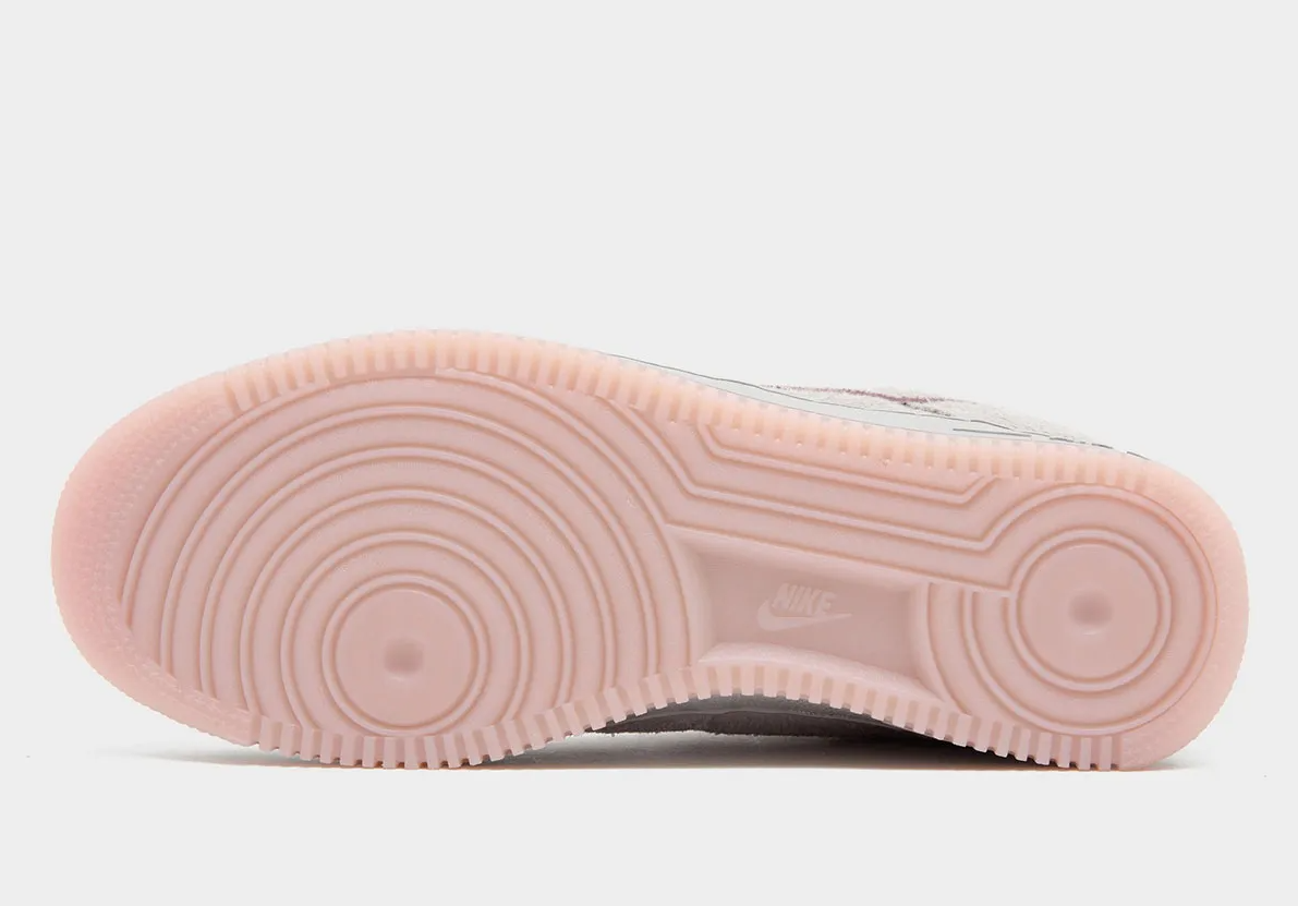 Close-up of the sole of a pink Nike sneaker with a textured, cushioned design.