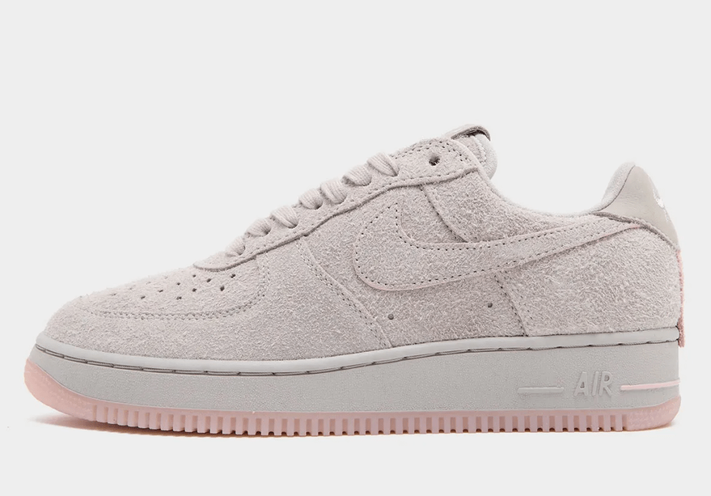 A gray Nike Air Force 1 sneaker with a light pink sole.