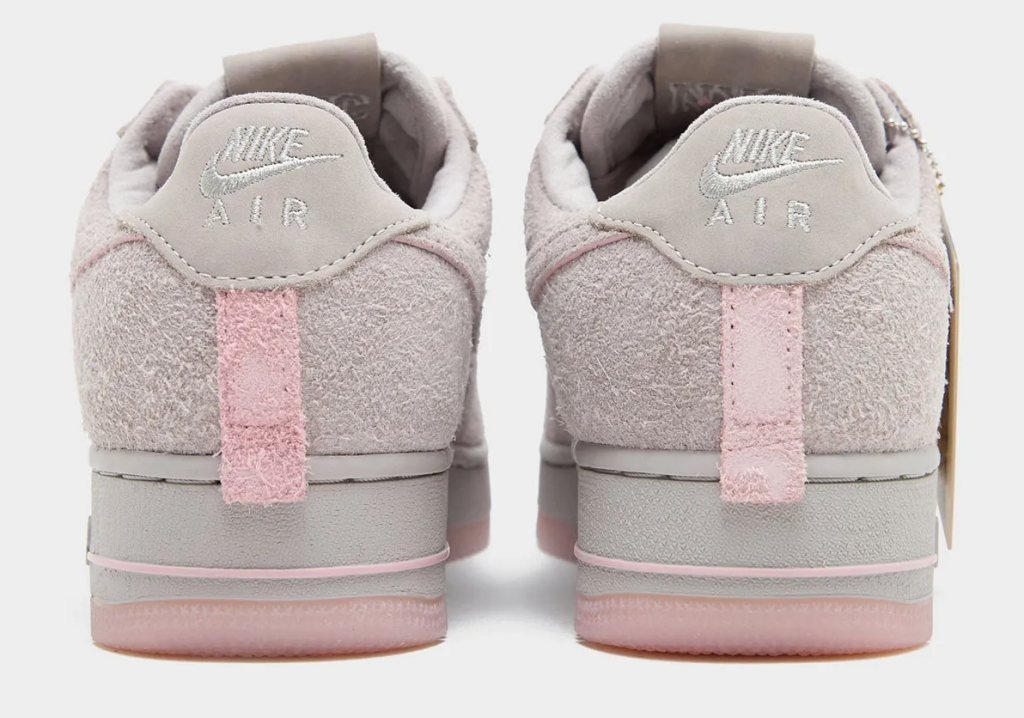 A pair of gray Nike Air sneakers with pink accents and the Nike Air logo.