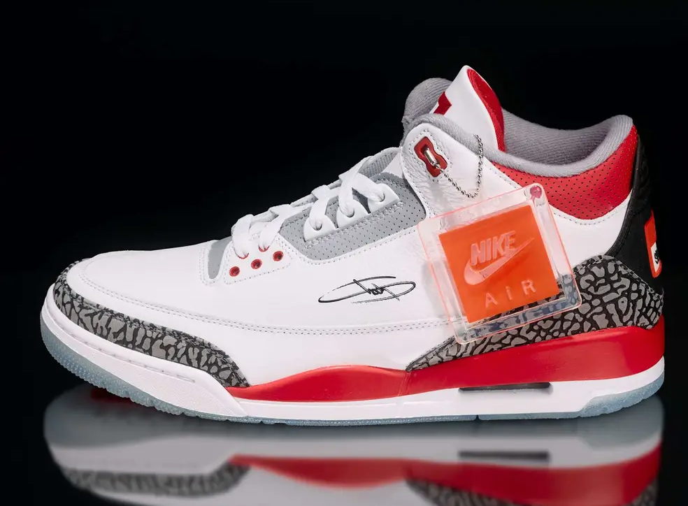 A pair of white, red, and gray Nike Air Jordan 3 sneakers with a visible Nike logo and "Air" branding.