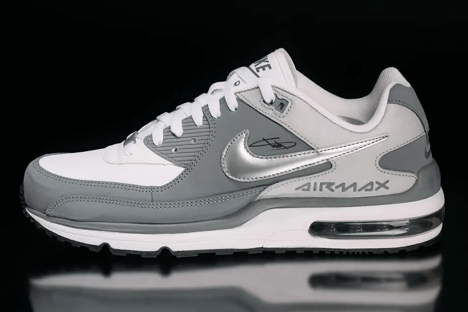 A pair of white and gray Nike Air Max sneakers with visible Air Max branding on the side.