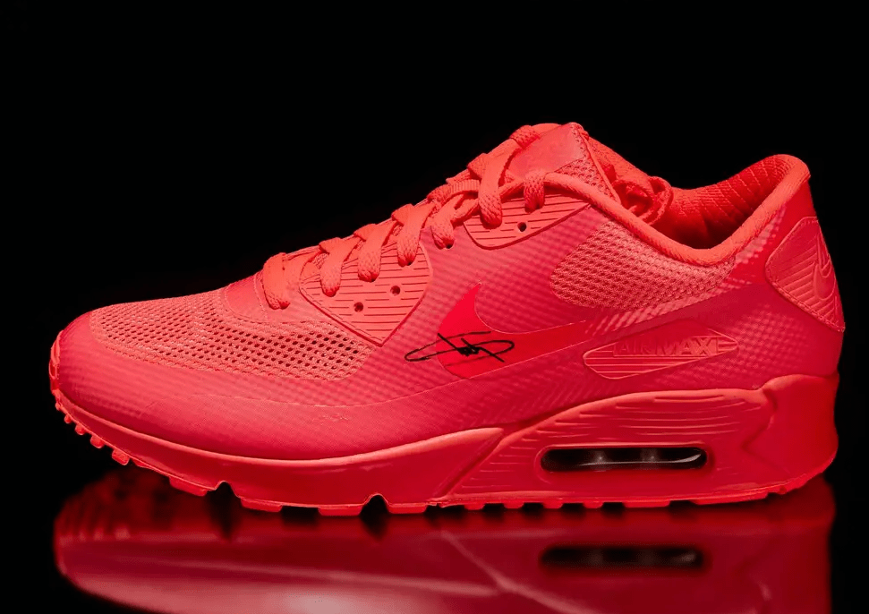 Bright red Nike Air Max 90 sneaker with textured upper and visible Air cushioning.