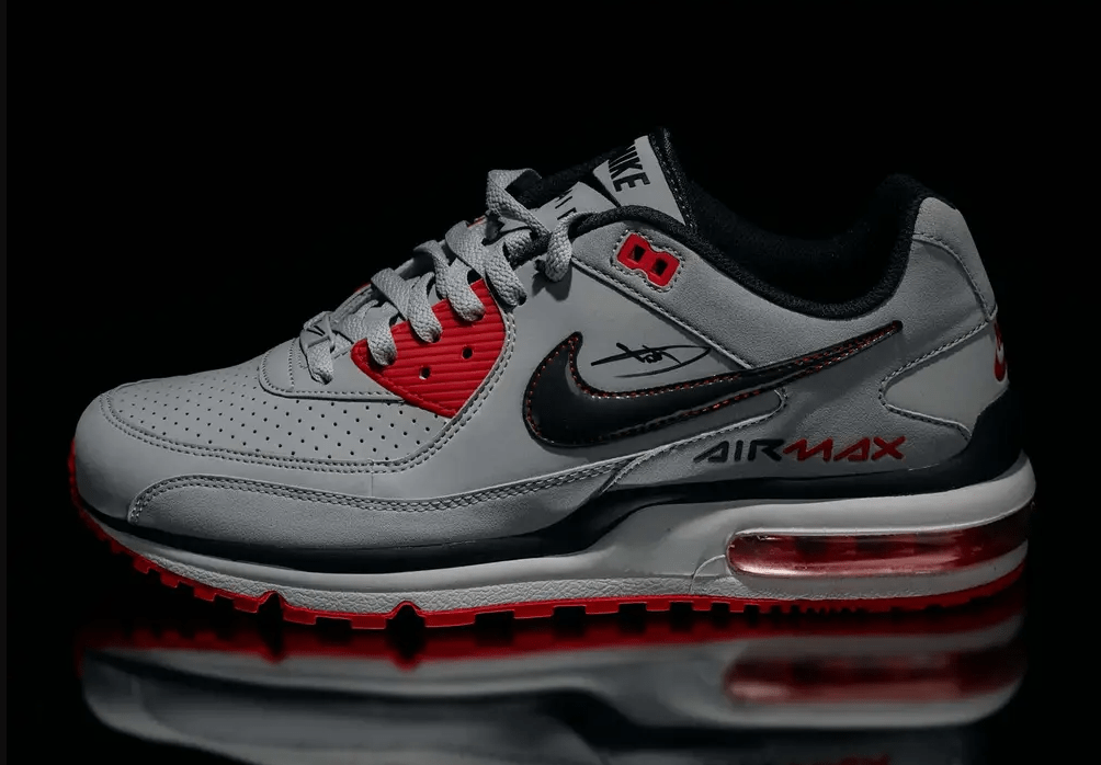 A pair of gray and red Nike Air Max sneakers with black accents, featuring the Nike logo and "Air Max" text.