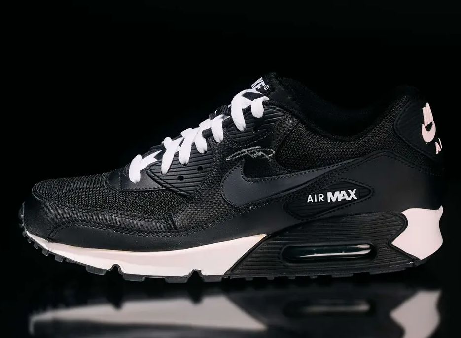 Black Nike Air Max 90 sneaker with white accents and "Air Max" text.