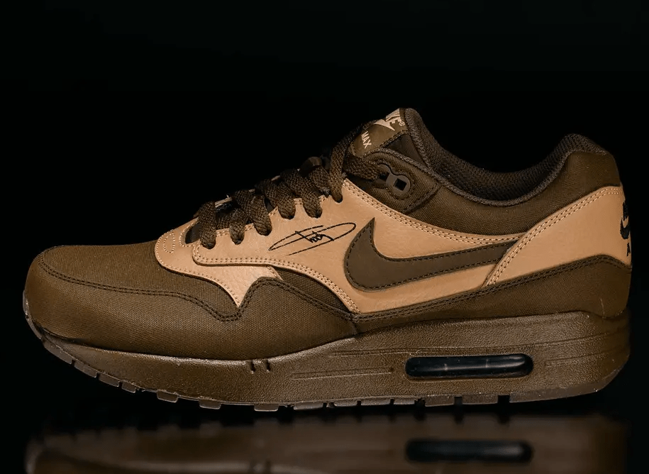 A pair of brown Nike Air Max 1 sneakers with a black sole and accents.