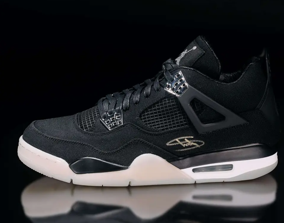Black Nike Air Jordan 4 sneaker with textured upper and visible Air unit in sole.