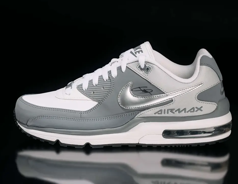 A pair of white and gray Nike Air Max sneakers with the Nike logo and "Air Max" text visible.