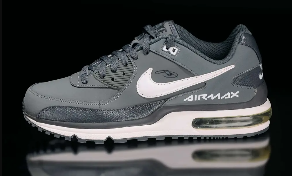 A pair of gray and white Nike Air Max sneakers with visible air cushioning in the sole.