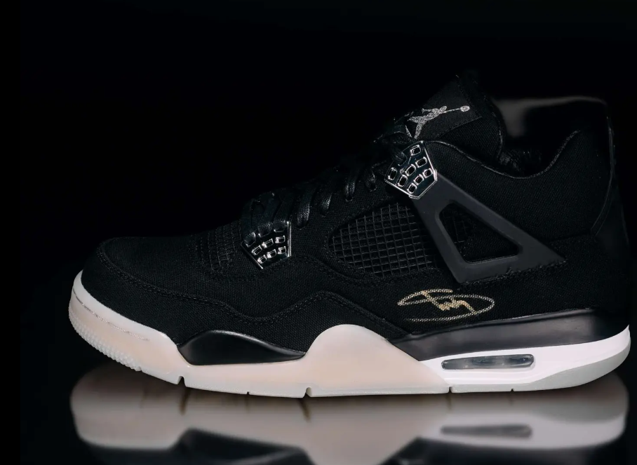 Black Nike Air Jordan 4 sneaker with textured upper and visible Air cushioning.