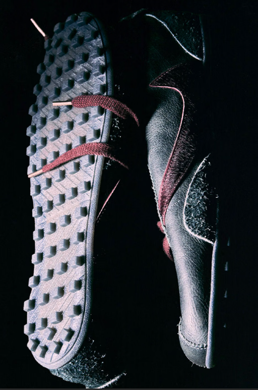 Close-up of a pair of black and pink athletic shoes with a textured sole pattern.