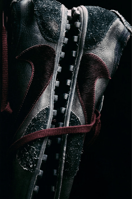 Close-up of a pair of black leather boots with red laces and metal eyelets.
