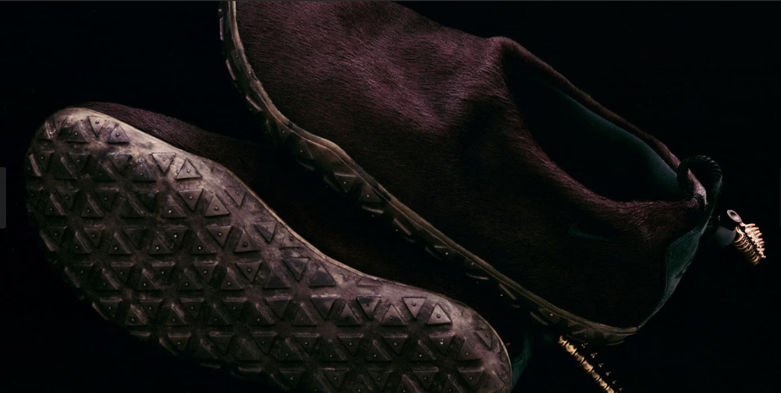 A close-up view of a pair of dark brown leather boots with a textured sole pattern.