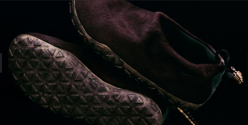 A close-up view of a pair of dark brown leather boots with a textured sole pattern.