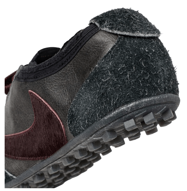 Black leather shoe with textured upper and rubber sole.