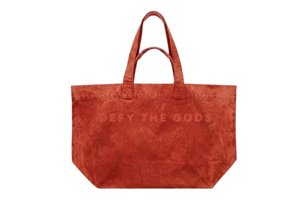 A large red tote bag with the text "DEFY THE GODS" printed on it.