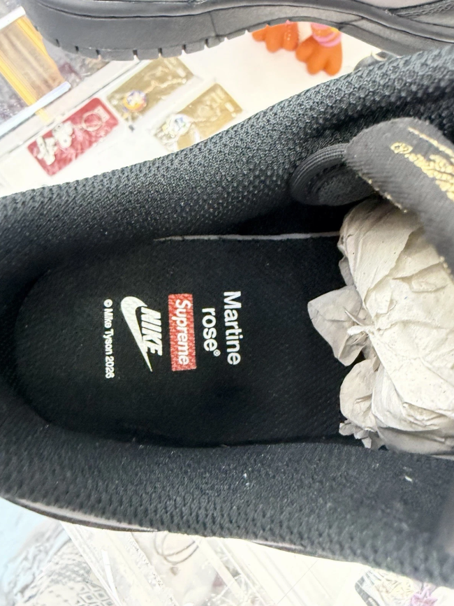 A black Nike shoe with the "Nike Sportswear" logo visible.