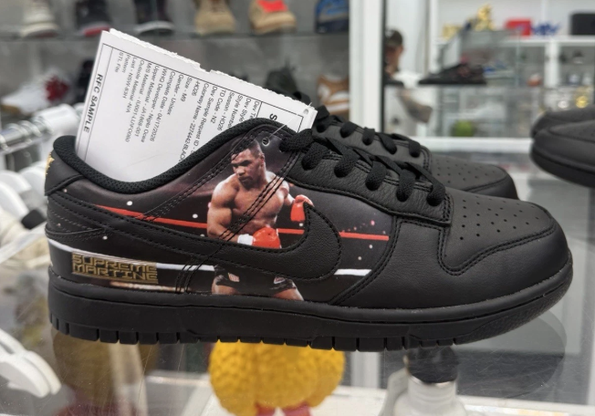A pair of black sneakers with a boxing-themed design, featuring a boxer image and text on the side.