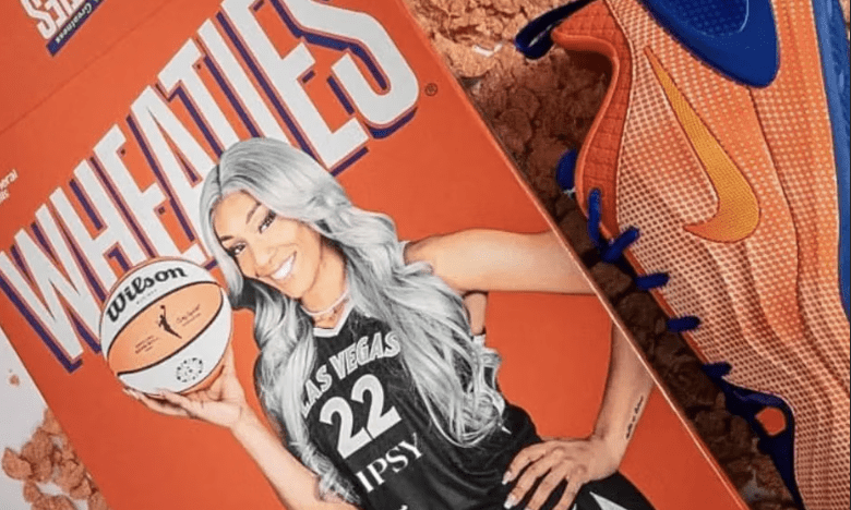 A woman wearing a basketball jersey with the number 22 and the text "Las Vegas Aces" is holding a basketball. The image also shows a pair of orange and blue basketball shoes.