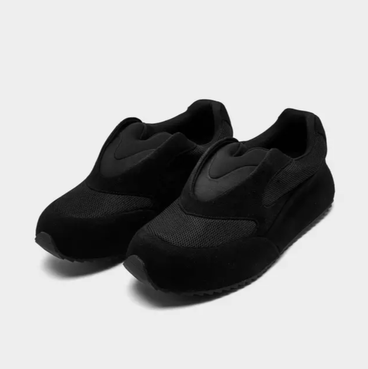 A pair of black athletic shoes with a mesh upper and thick sole.