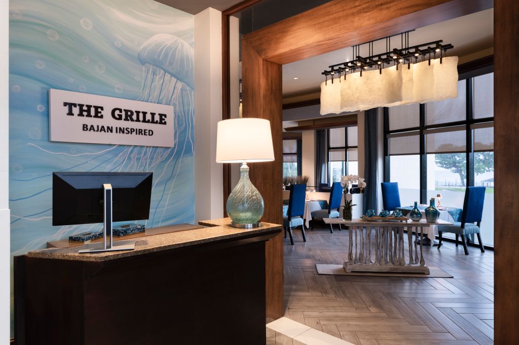 The Grille Bajan inspired restaurant interior with wooden beams, lighting fixtures, and blue accents.