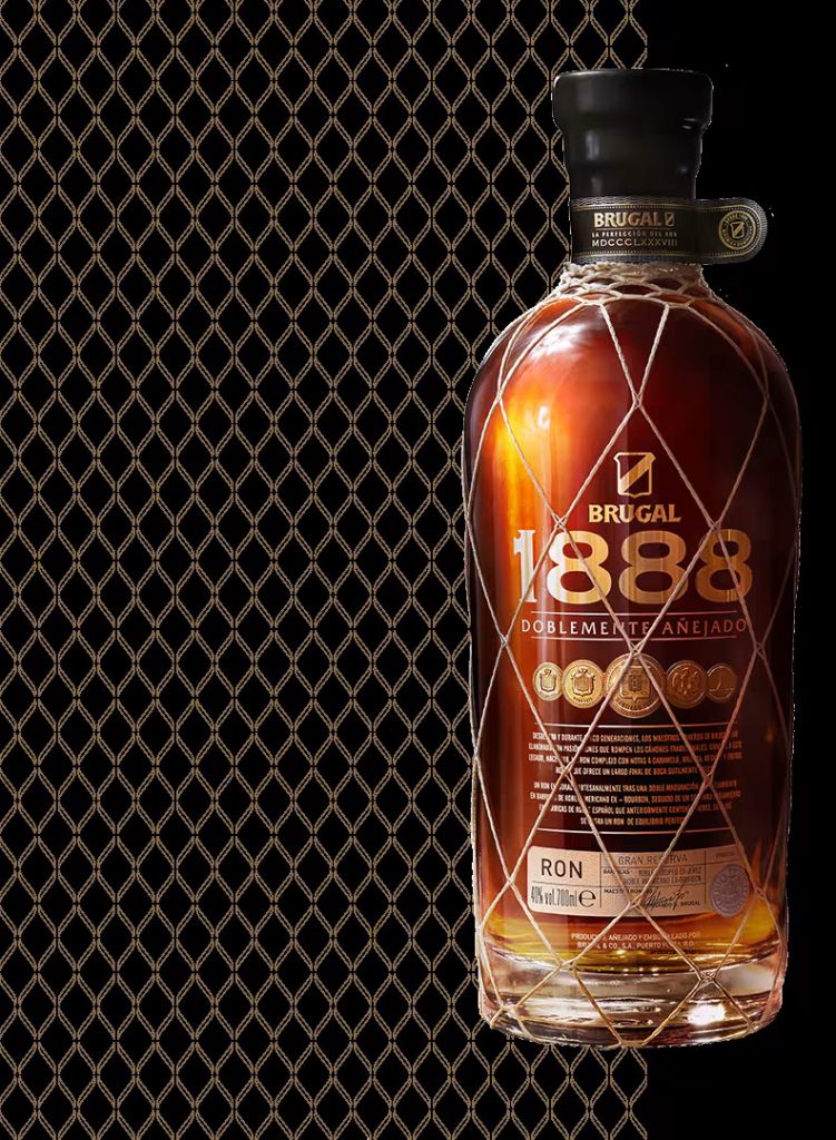 Bottle of Brugal 1888 rum against a black and gold diamond pattern background.