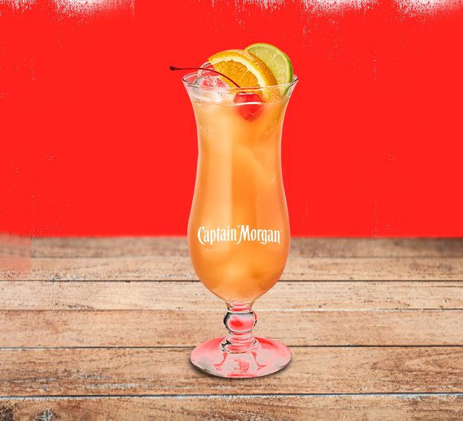 A glass of orange cocktail garnished with orange and lime slices, featuring the Captain Morgan logo.